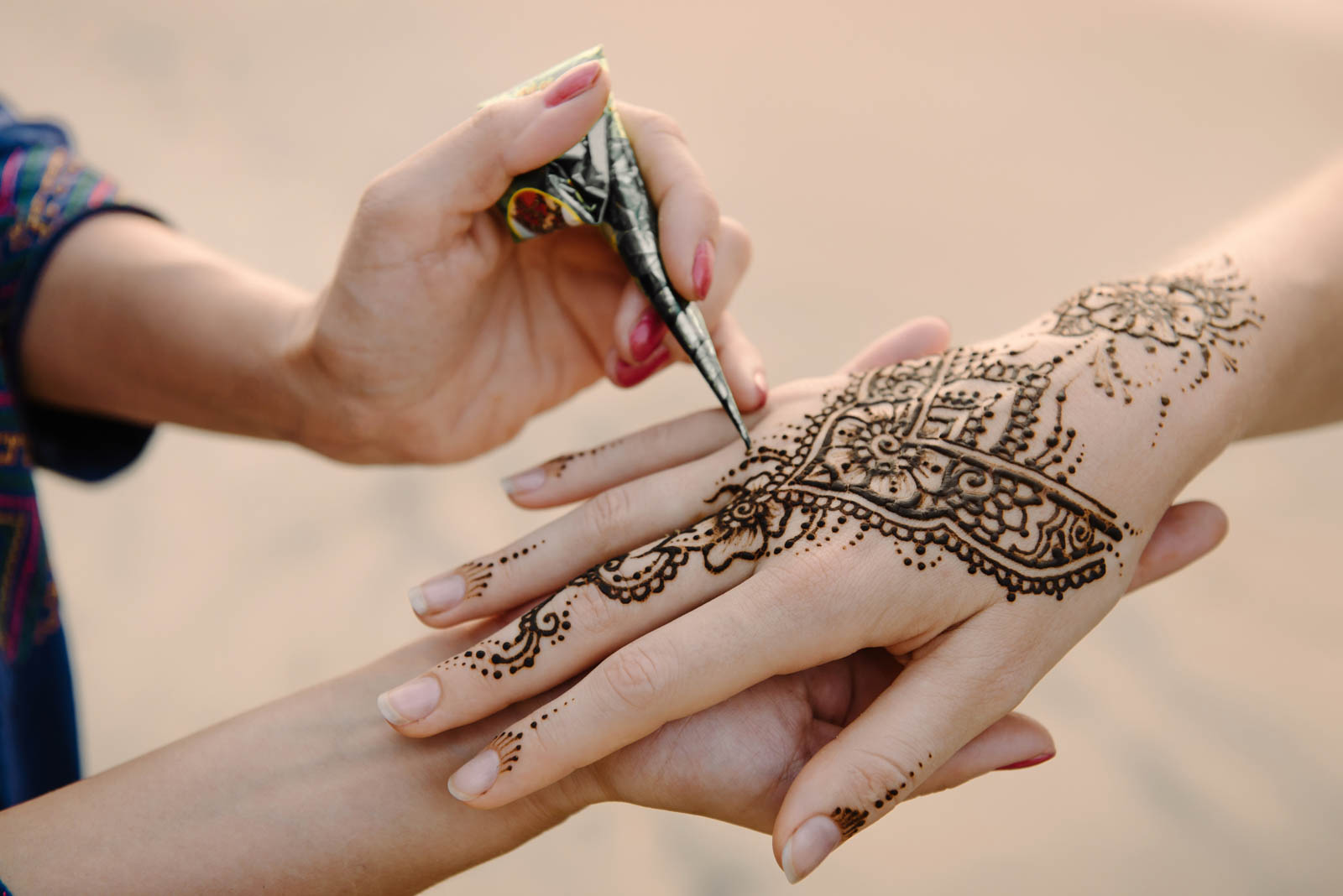 Woman receiving traditional Henna art on hands
